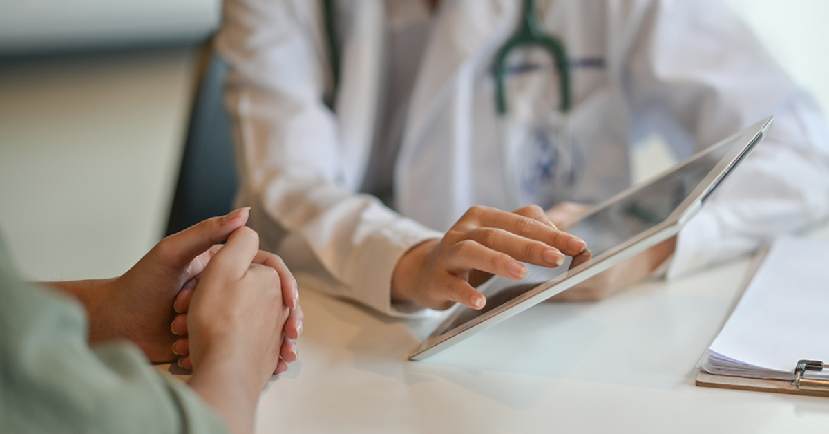 A doctor's hand scrolling on an iPad